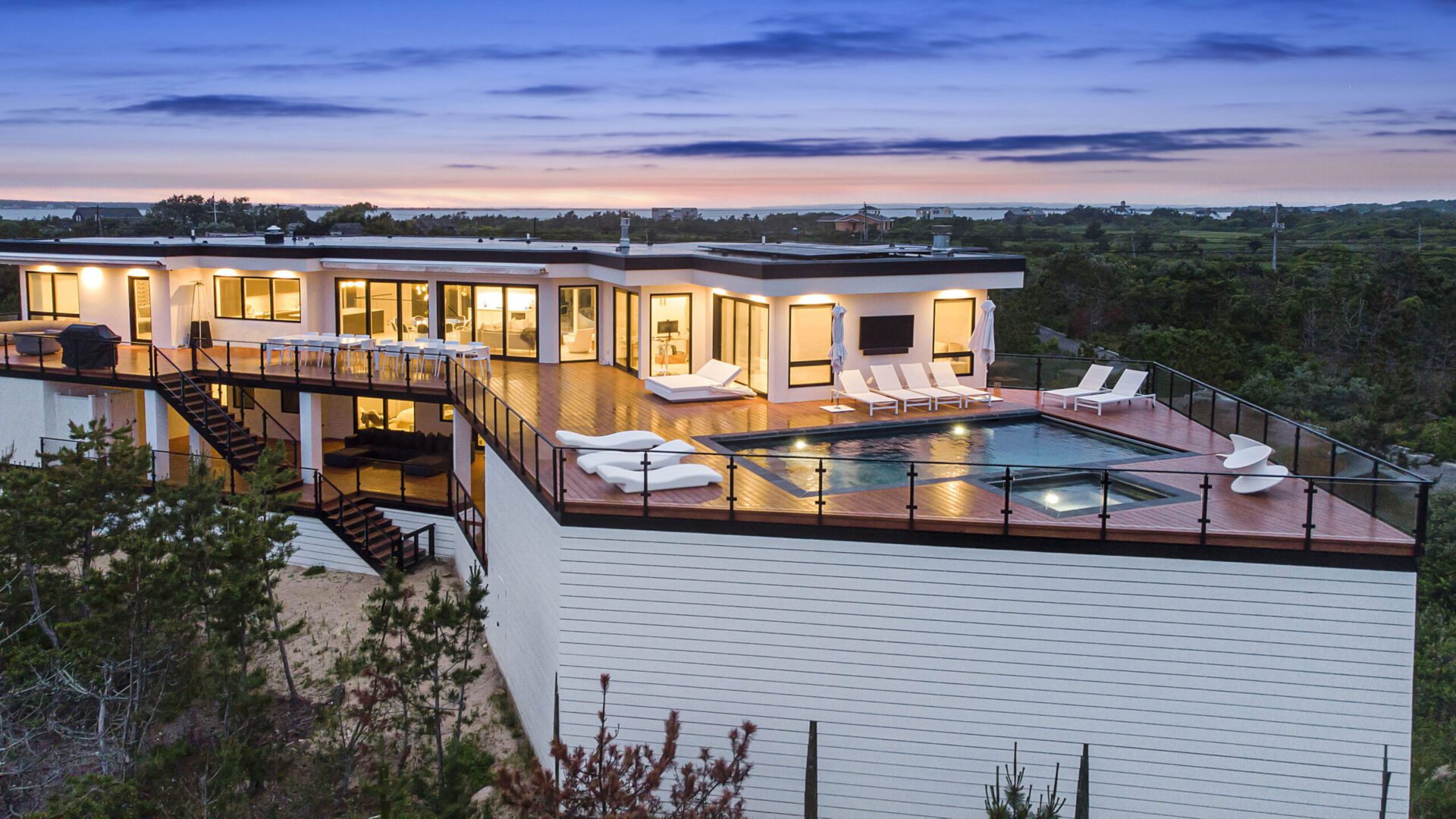 A large white house with a pool and deck.