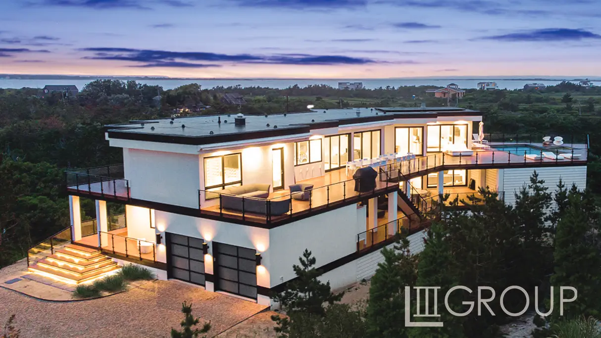 A large white building with a balcony and garage.